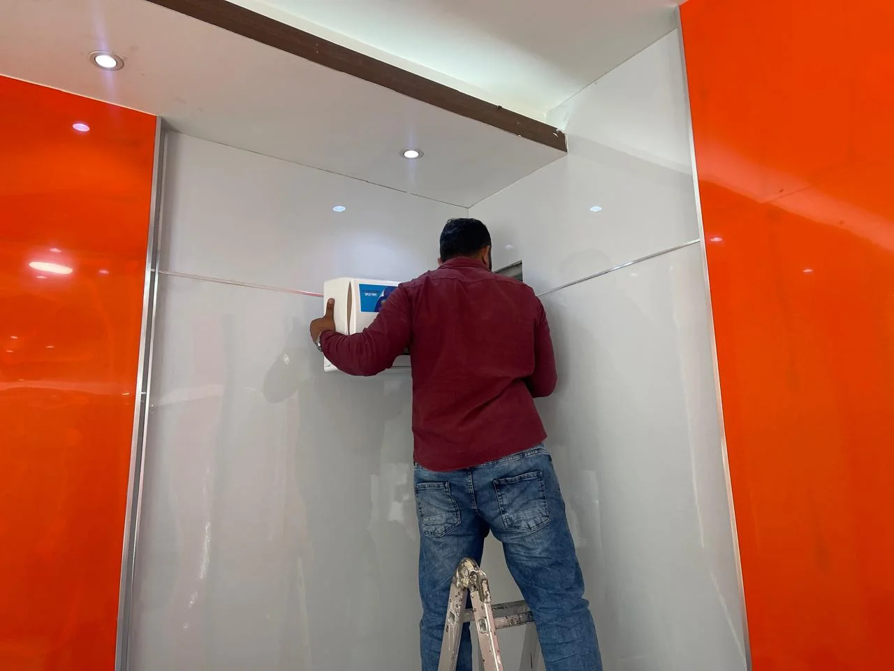 Technician installing a wall-mounted split AC unit in Dubai