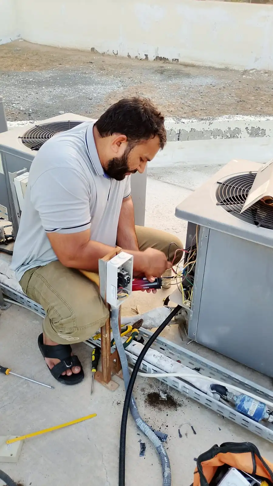 Technicians repairing a wall-mounted AC unit in a Dubai property — supporting project view 1