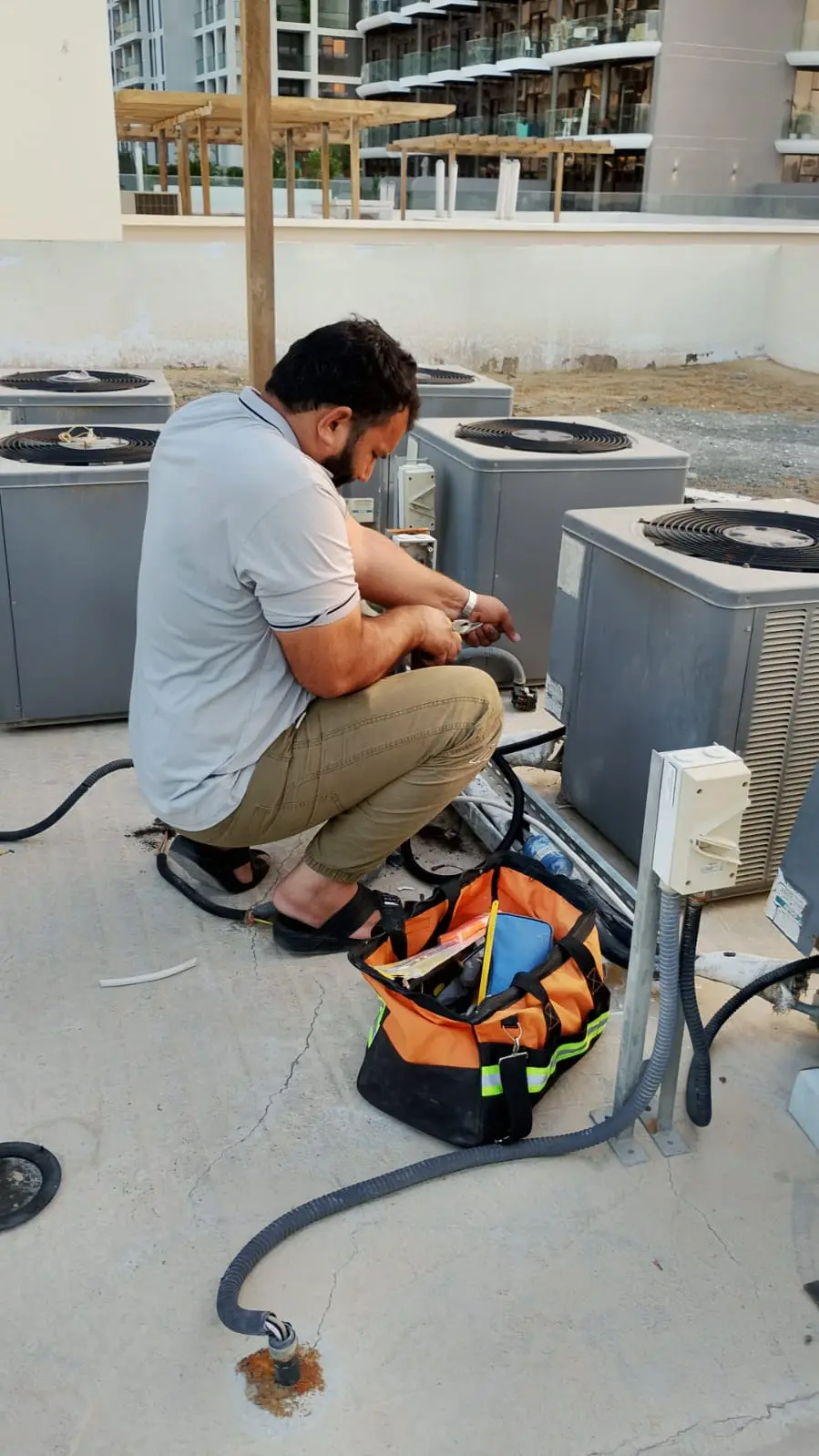 Technicians repairing a wall-mounted AC unit in a Dubai property — supporting project view 2