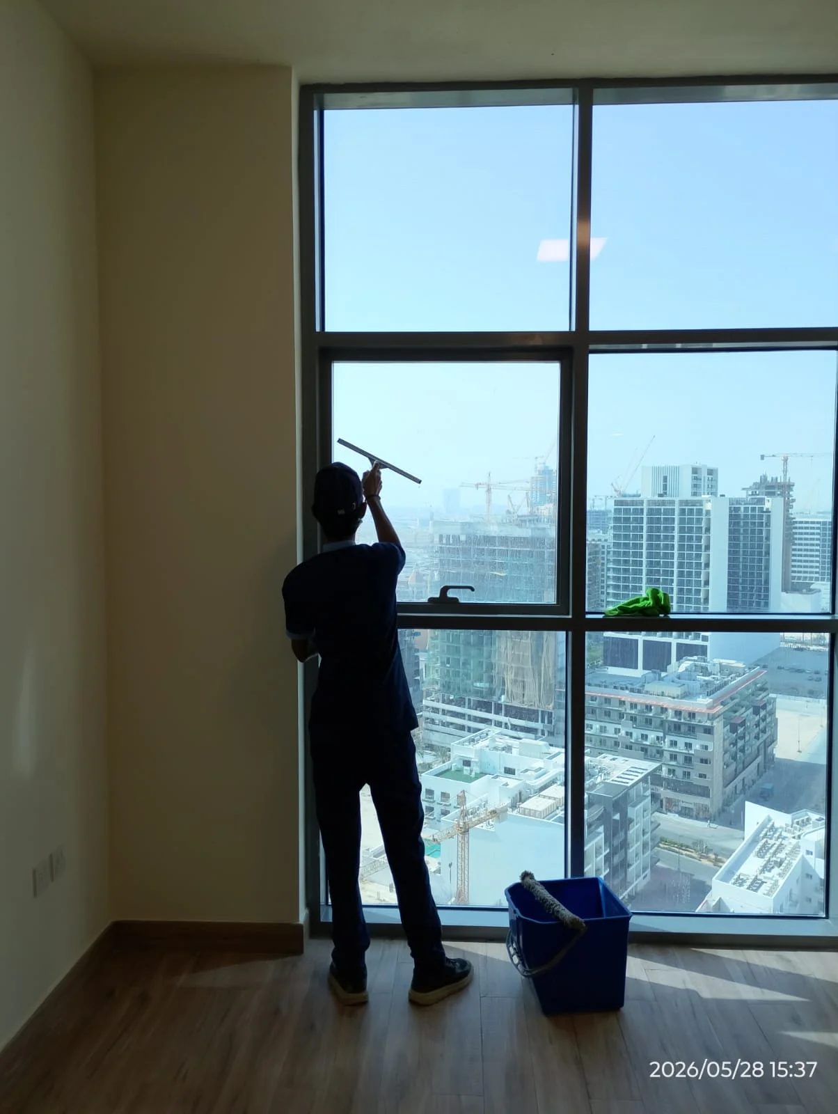 Cleaner washing a large apartment window in Dubai