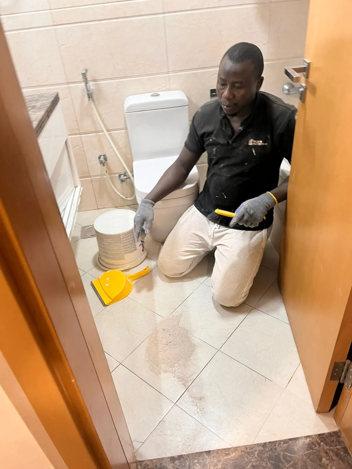 Technician applying waterproofing treatment to a bathroom floor in Dubai